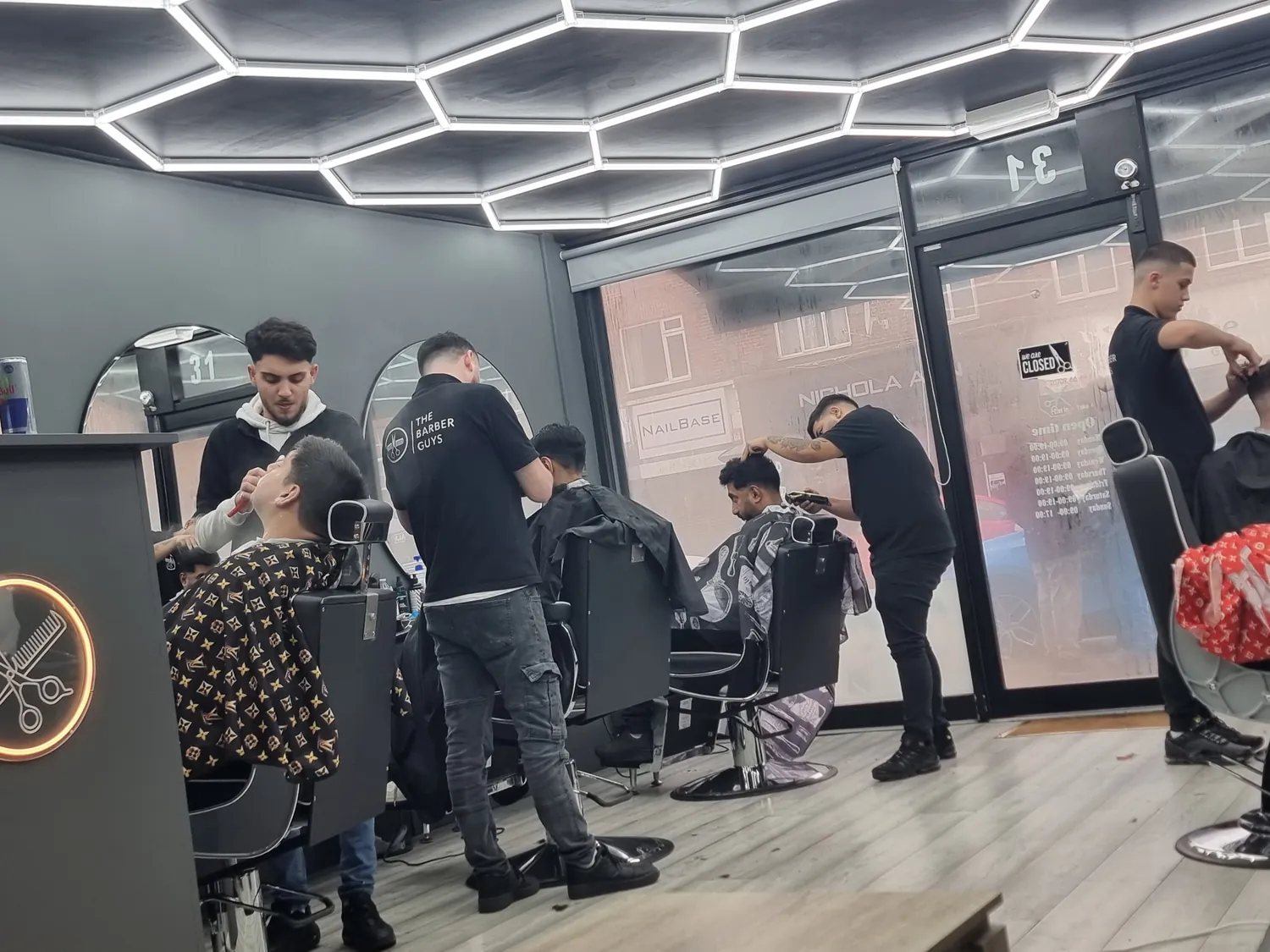 The shop floor mid-session with several barbers working