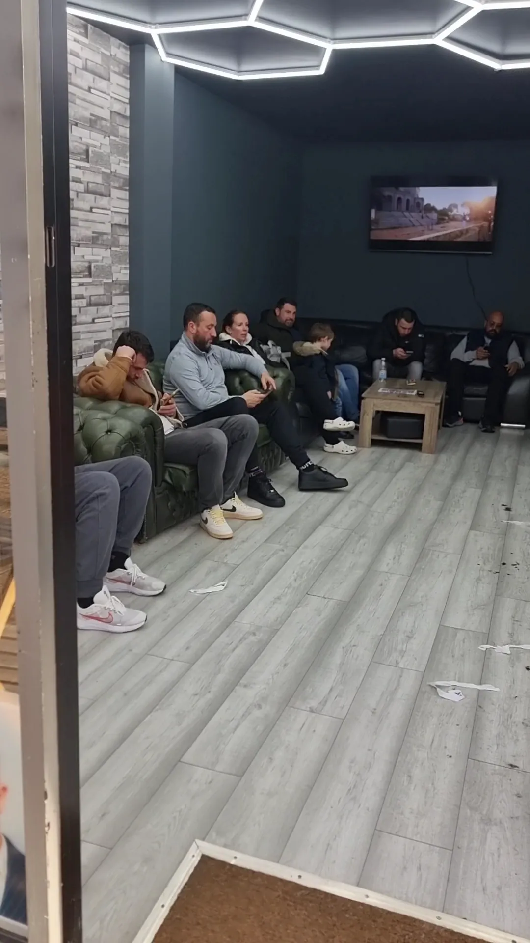 Leather Chesterfield waiting area with wall-mounted TV