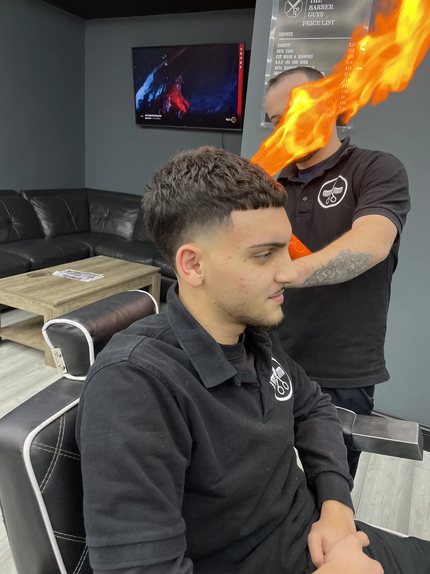 A barber finishing a cut with an ear flaming torch
